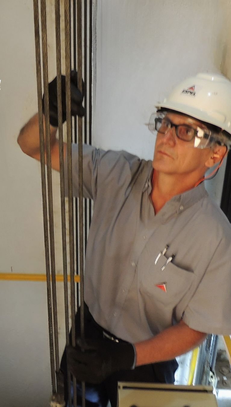 Técnico da Espel realizando manutenção no poço do elevador